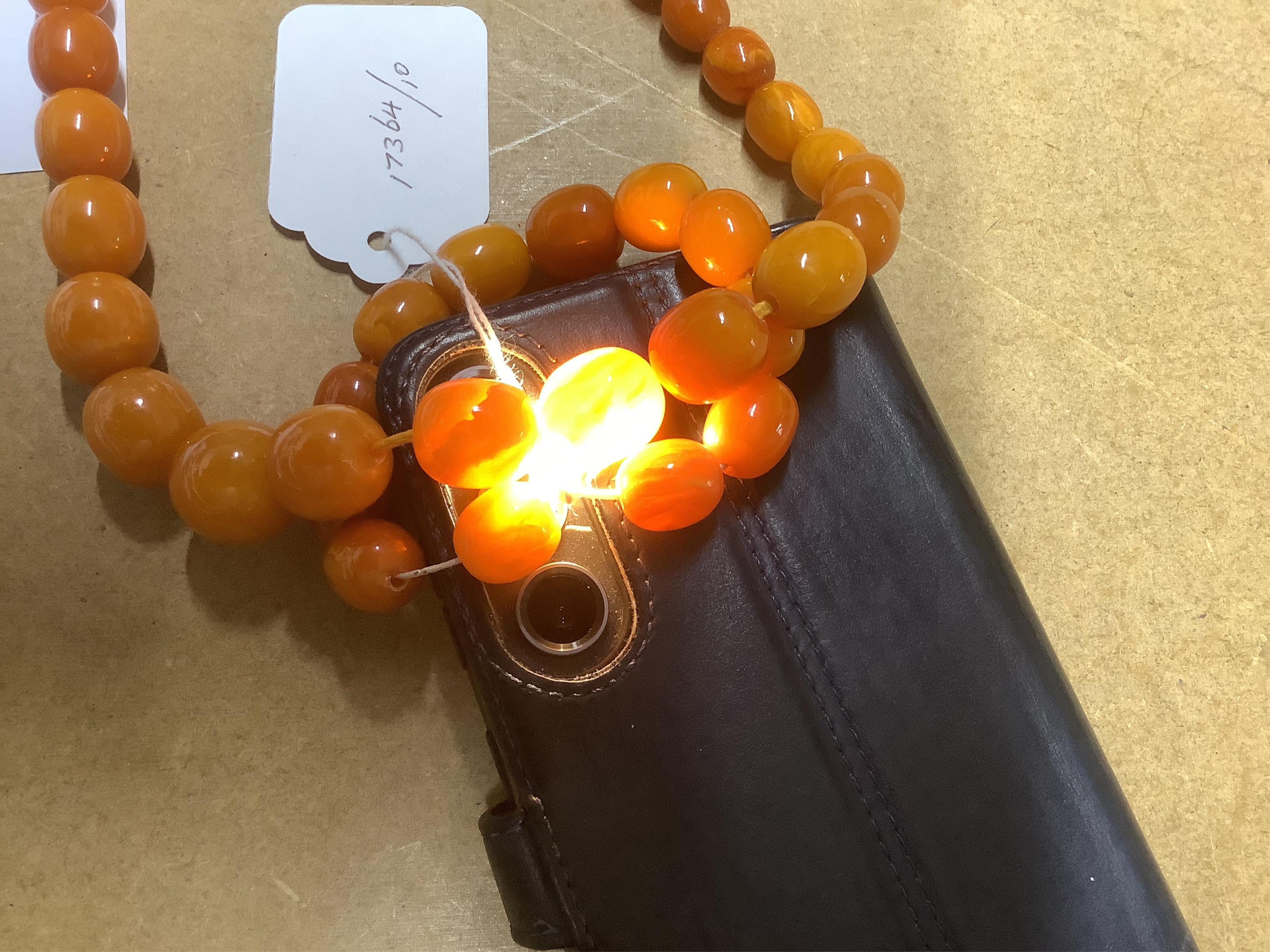 A single strand graduated amber bead necklace, 70cm, gross weight 67 grams, together with an amber bead bracelet, gross weight 20 grams. Condition - poor to fair